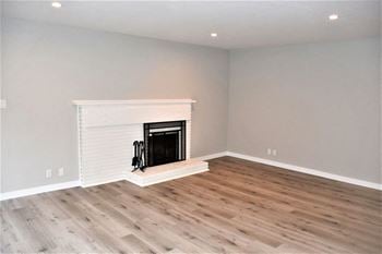 A living room with a fireplace and wooden floors
